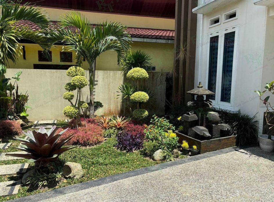 Taman depan rumah dengan air mancur batu